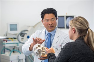 Prof. Dr. Nakamura mit Modell eines Schädels, Foto Steinbach/Ahrens