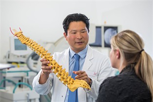 Prof. Dr. Nakamura mit dem Modell einer Wirbelsäule, Foto Steinbach/Ahrens