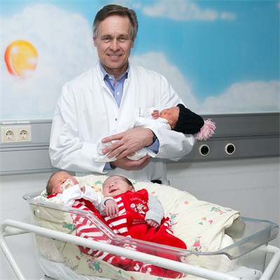 Prof. Dr. Werner Neuhaus, Chefarzt der Frauenklinik, mit drei Neugeborenen, ©Fürst-Fastré